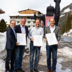 Günther Strobl und Otto Bacher (TÜV AUSTRIA CERT) mit Rupert Walchhofer und Michael Walchhofer vor ihrem Hotel Zauchensee Hof im Salzburger Land