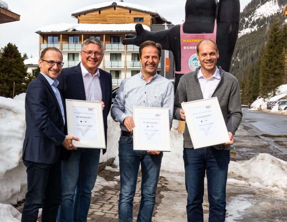 Günther Strobl und Otto Bacher (TÜV AUSTRIA CERT) mit Rupert Walchhofer und Michael Walchhofer vor ihrem Hotel Zauchensee Hof im Salzburger Land